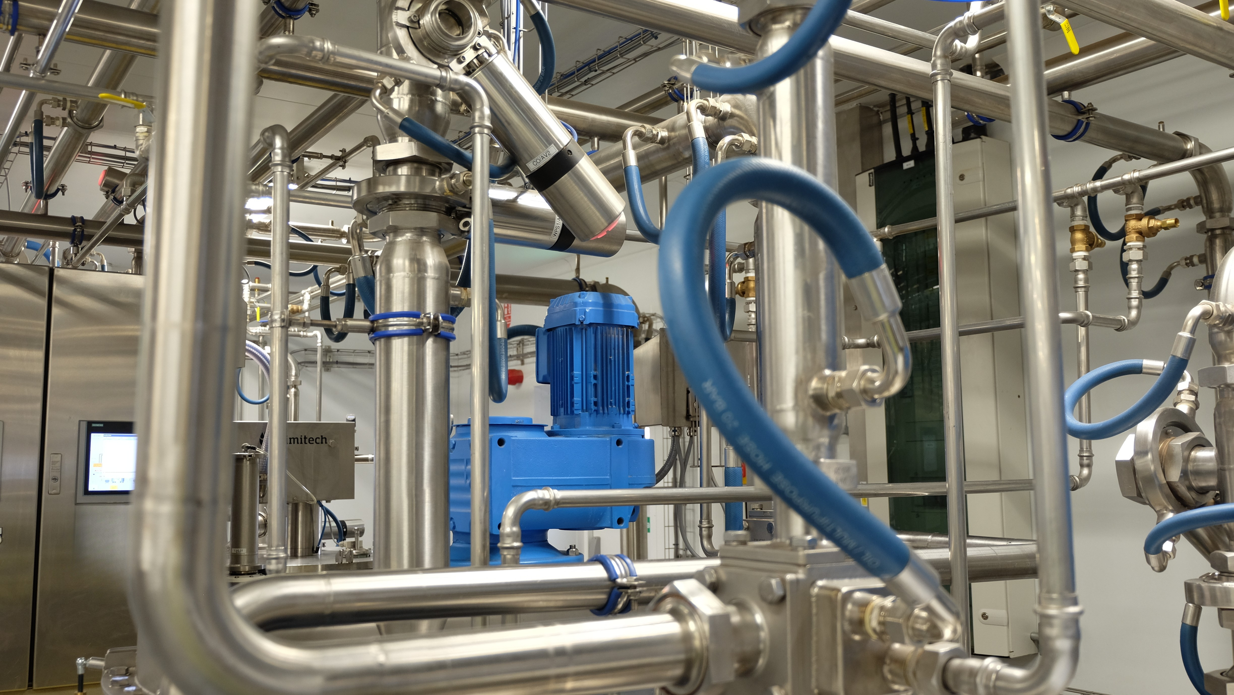 Stainless steel chocolate processing equipment and pipes in a production facility.