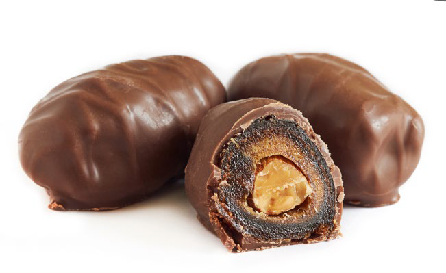 A close-up of three confectionery products cased in chocolate.