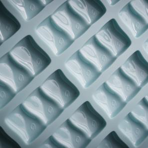 A close-up of a polycarbonate mould for industrial chocolate production.