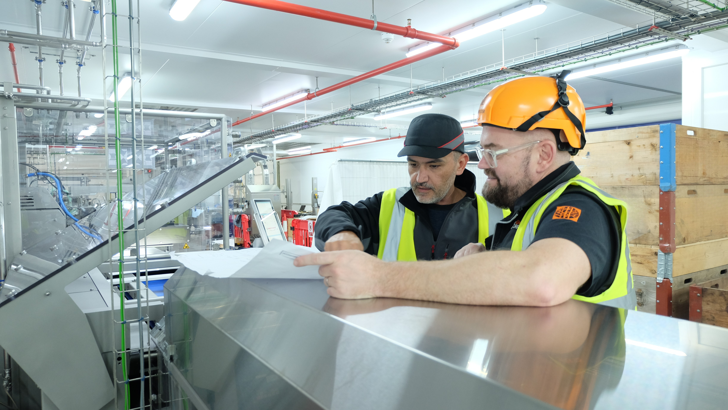 Mike Gee assessing factory plans with a factory worker. 