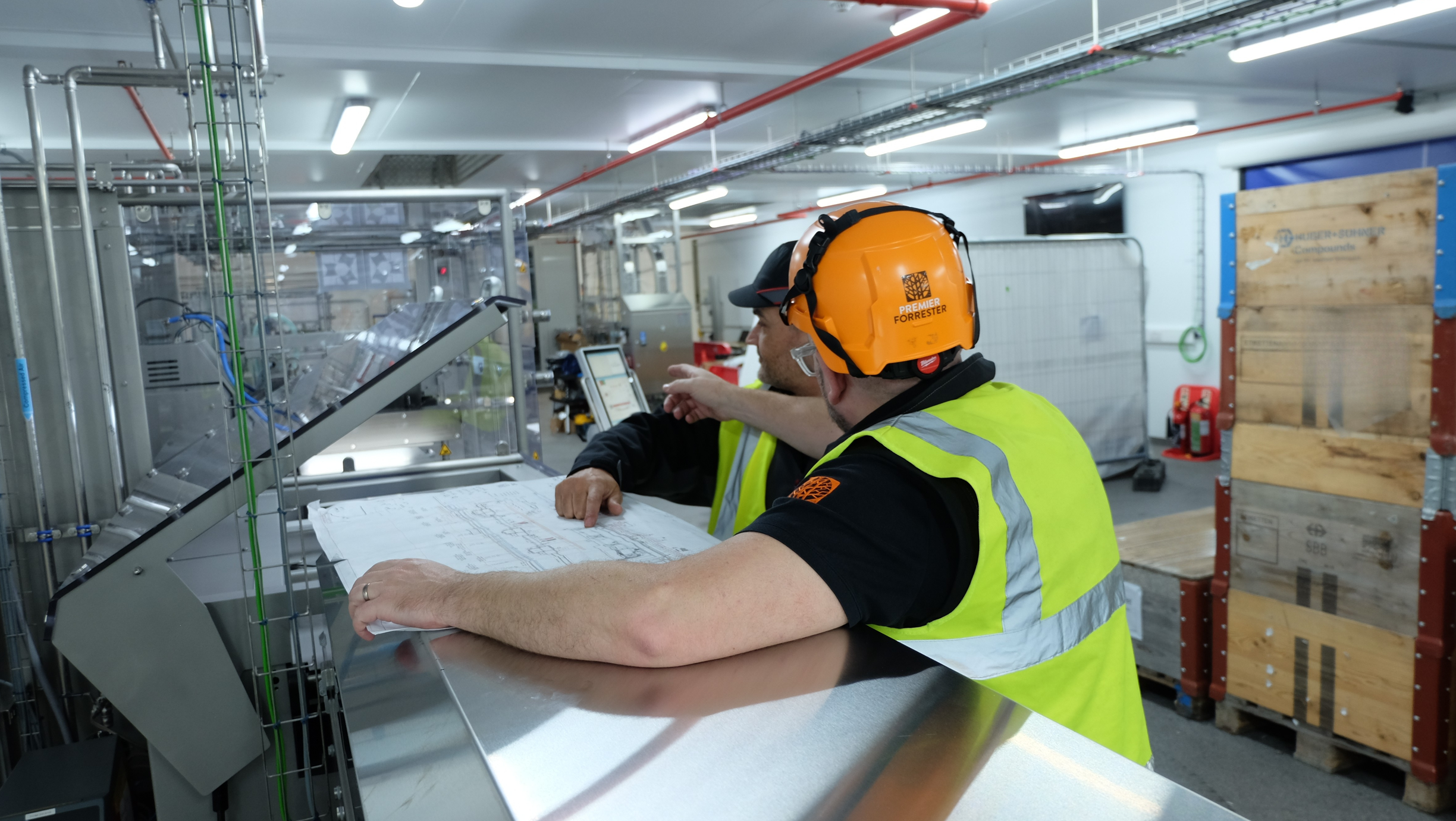 Mike Gee assessing factory plans with a factory worker. 
