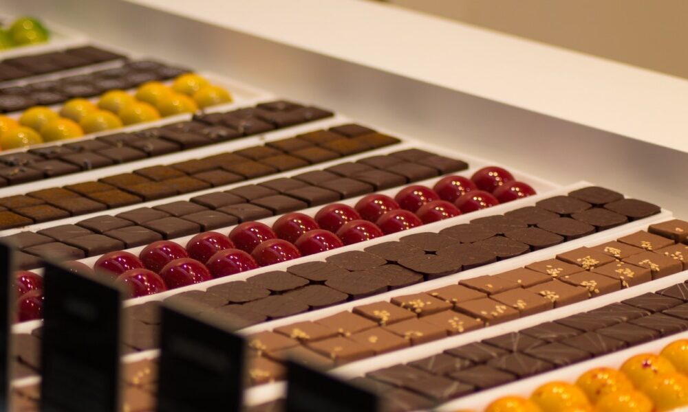 Display of assorted chocolates and pralines arranged in neat rows.