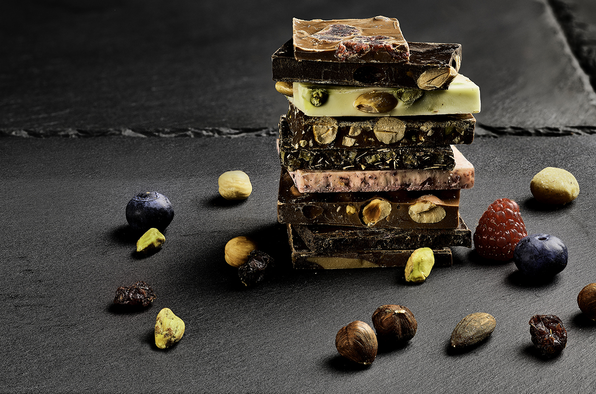 Nine slabs of chocolate, showing a variety of fruit and nut fillings.