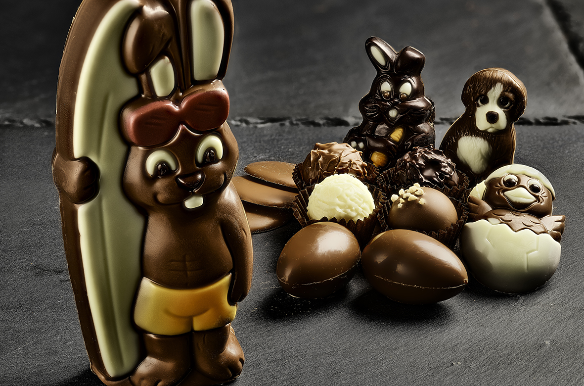 An assortment of decorated chocolates arranged on a slate surface.