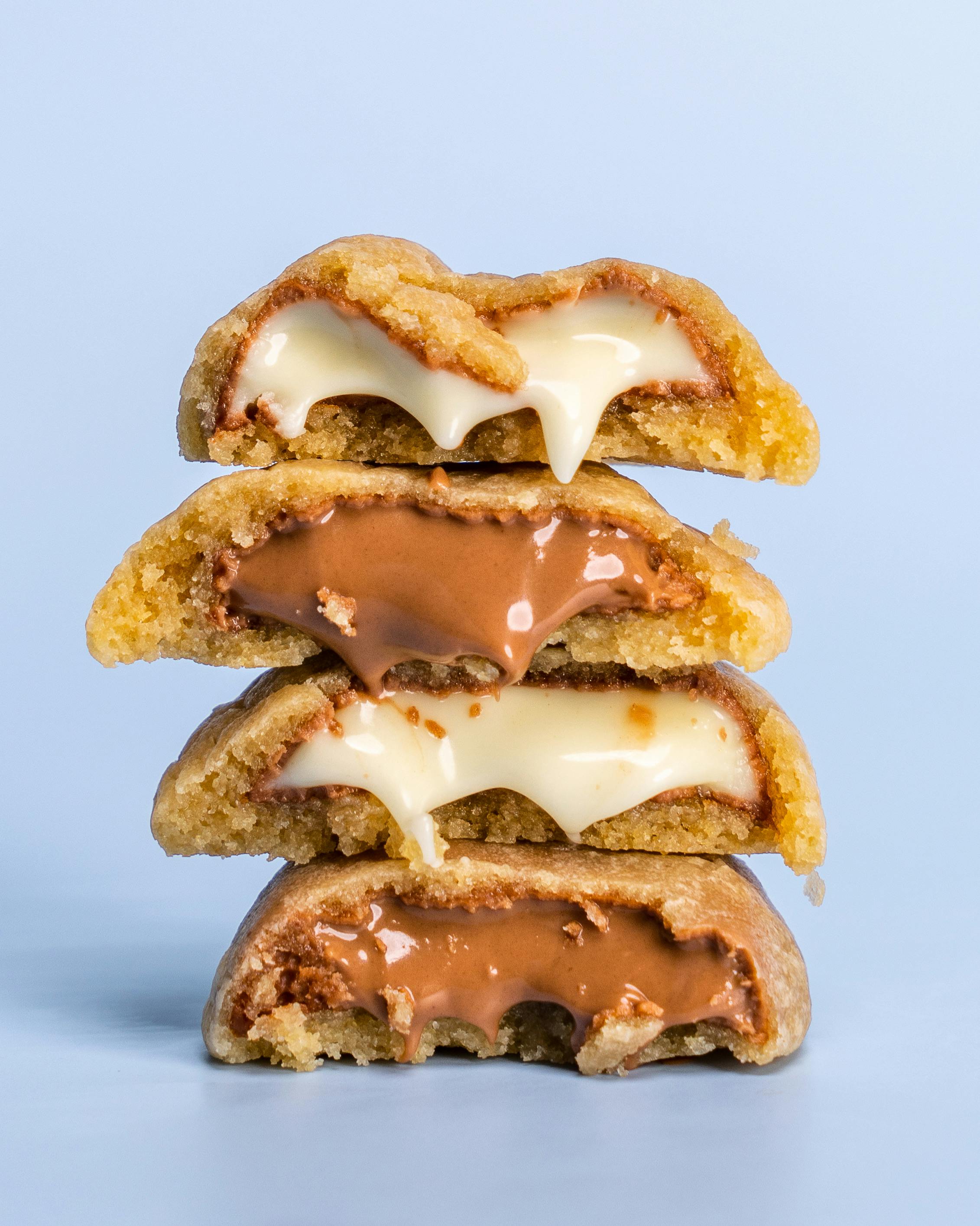 Close-up of chocolate-filled cookies with gooey milk and white chocolate centres.
