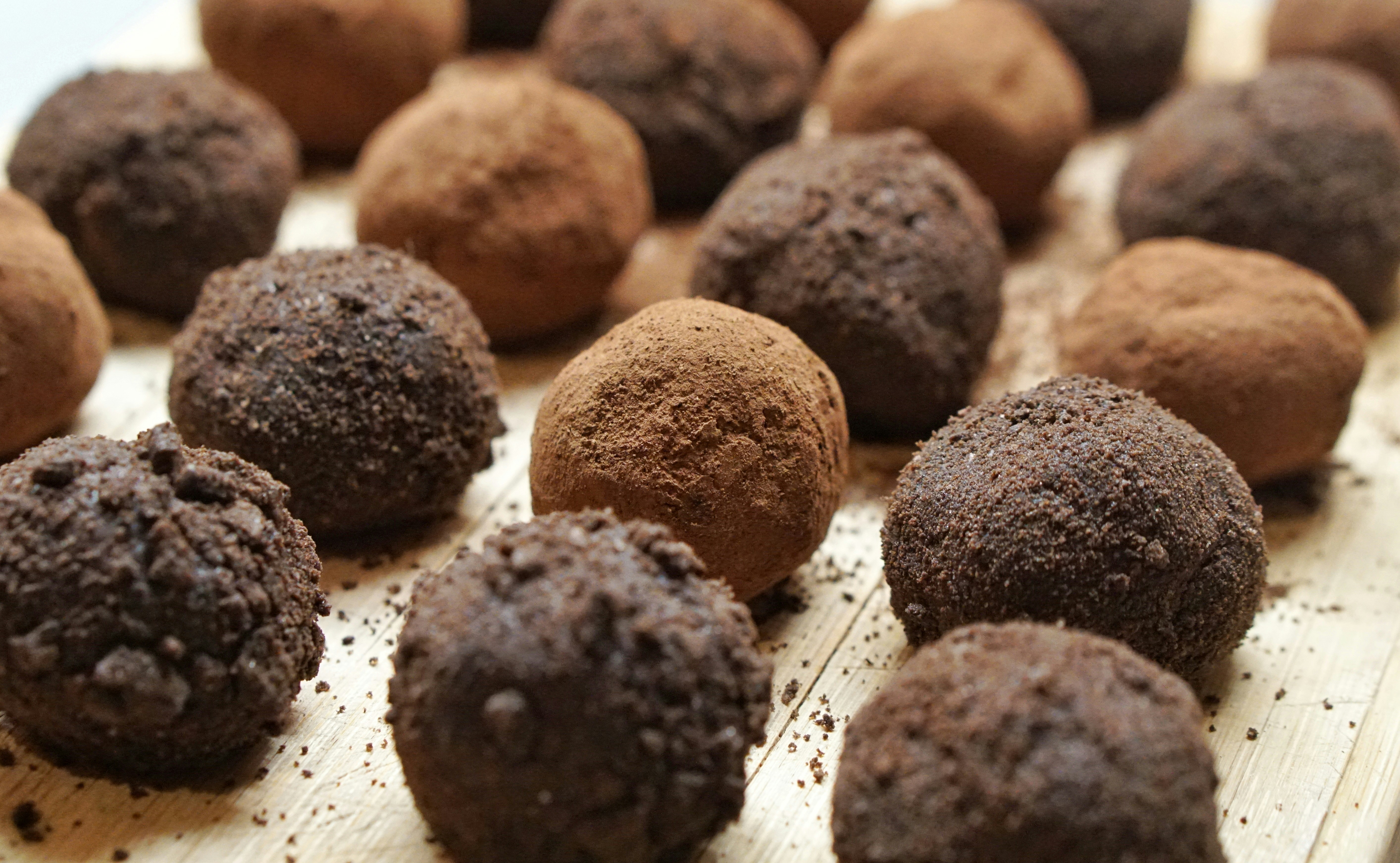 Chocolate truffles arranged in lines dusted with milk and dark chocolate.