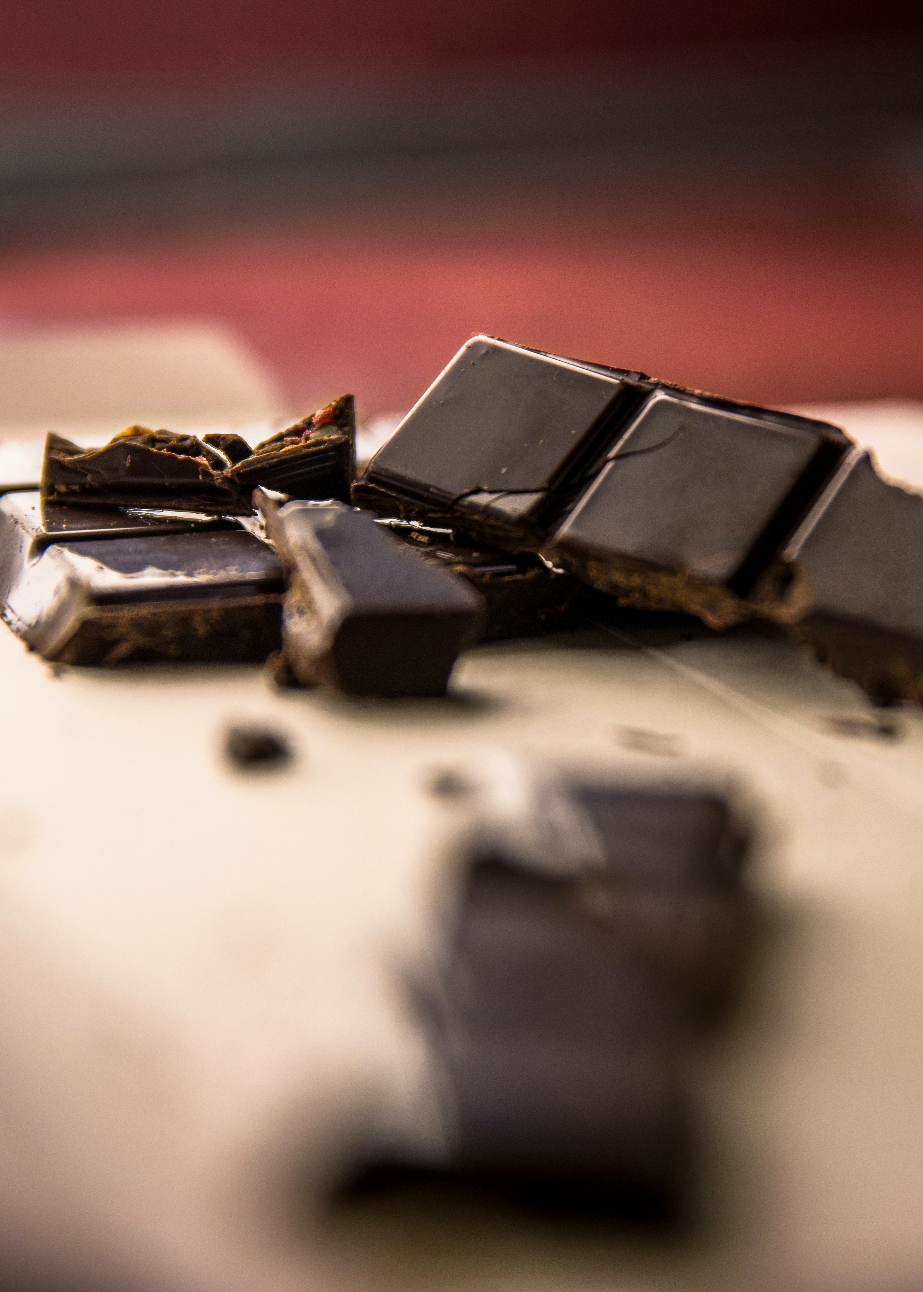 Close-up of broken pieces of filled dark chocolate on a light surface.