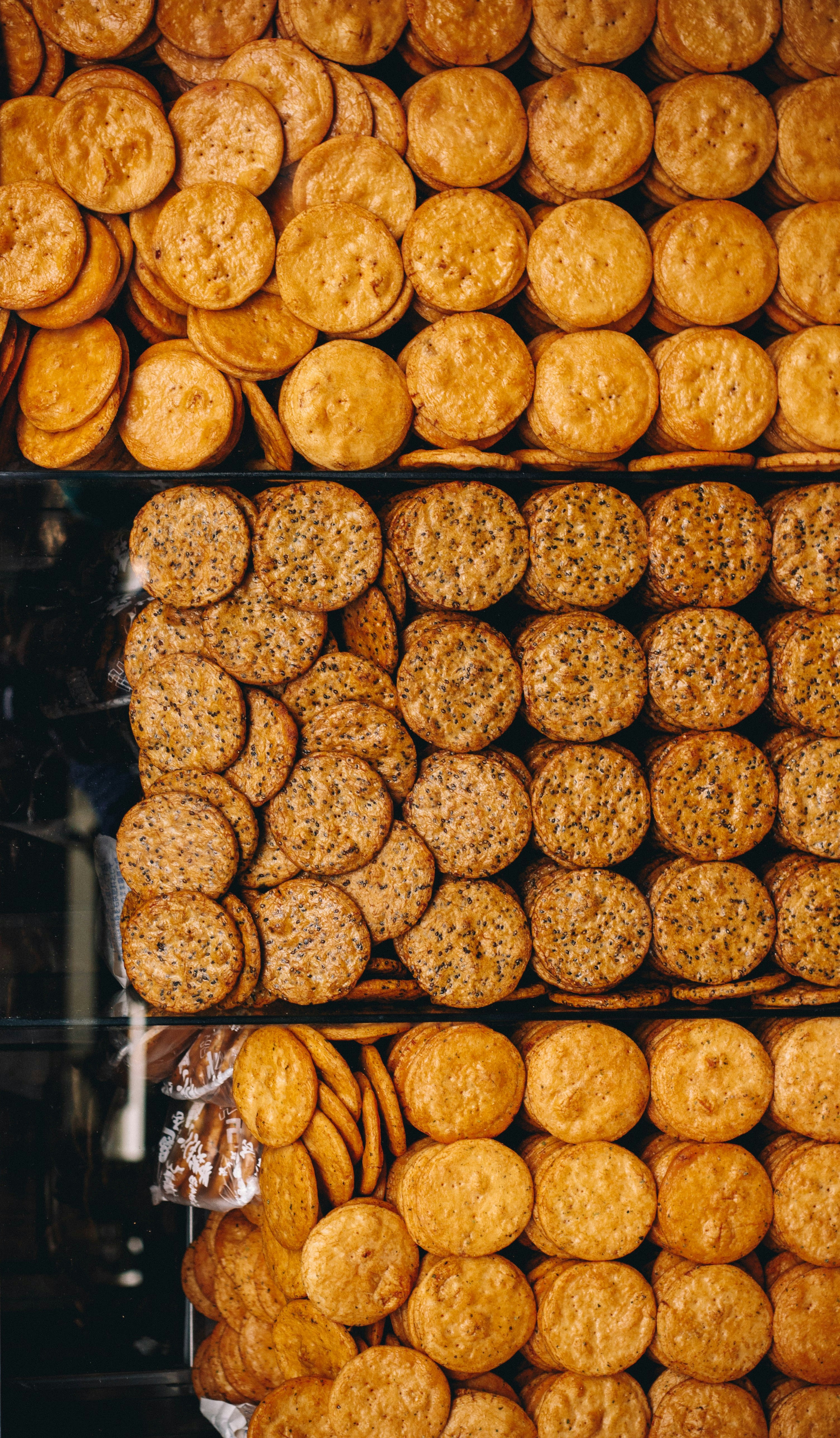 Rows of stacked round crackers with plain and seeded varieties.