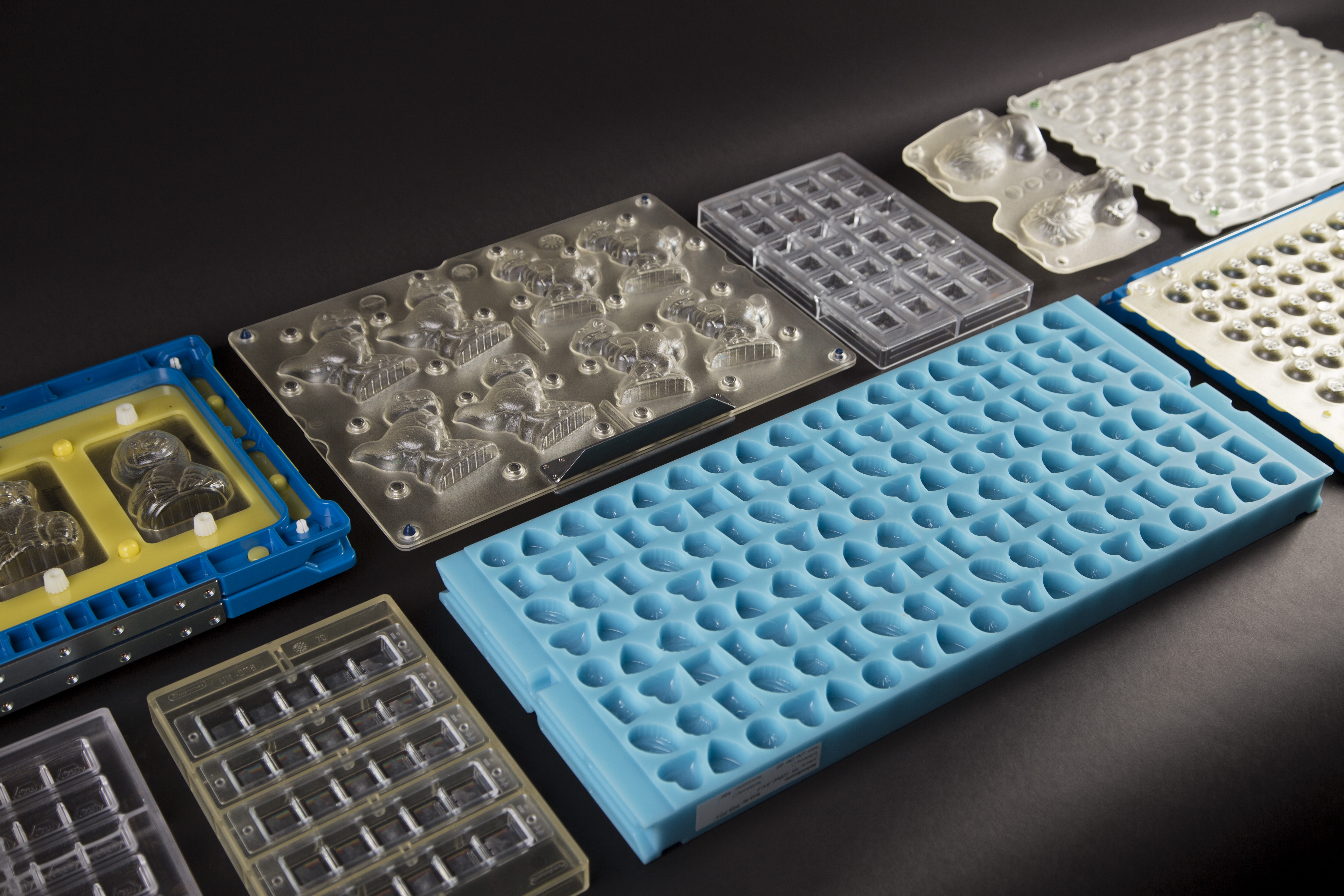 An assortment of Hans Brunner chocolate moulds. Shapes include hearts, drops, and animals.