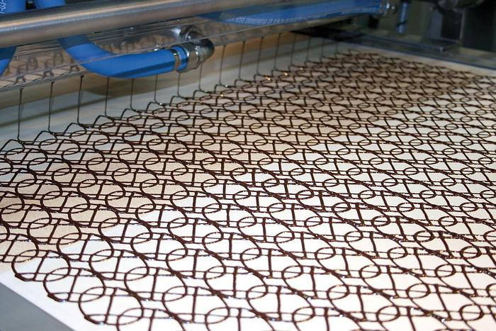 Image of a chocolate decorator machine drawing swirls.