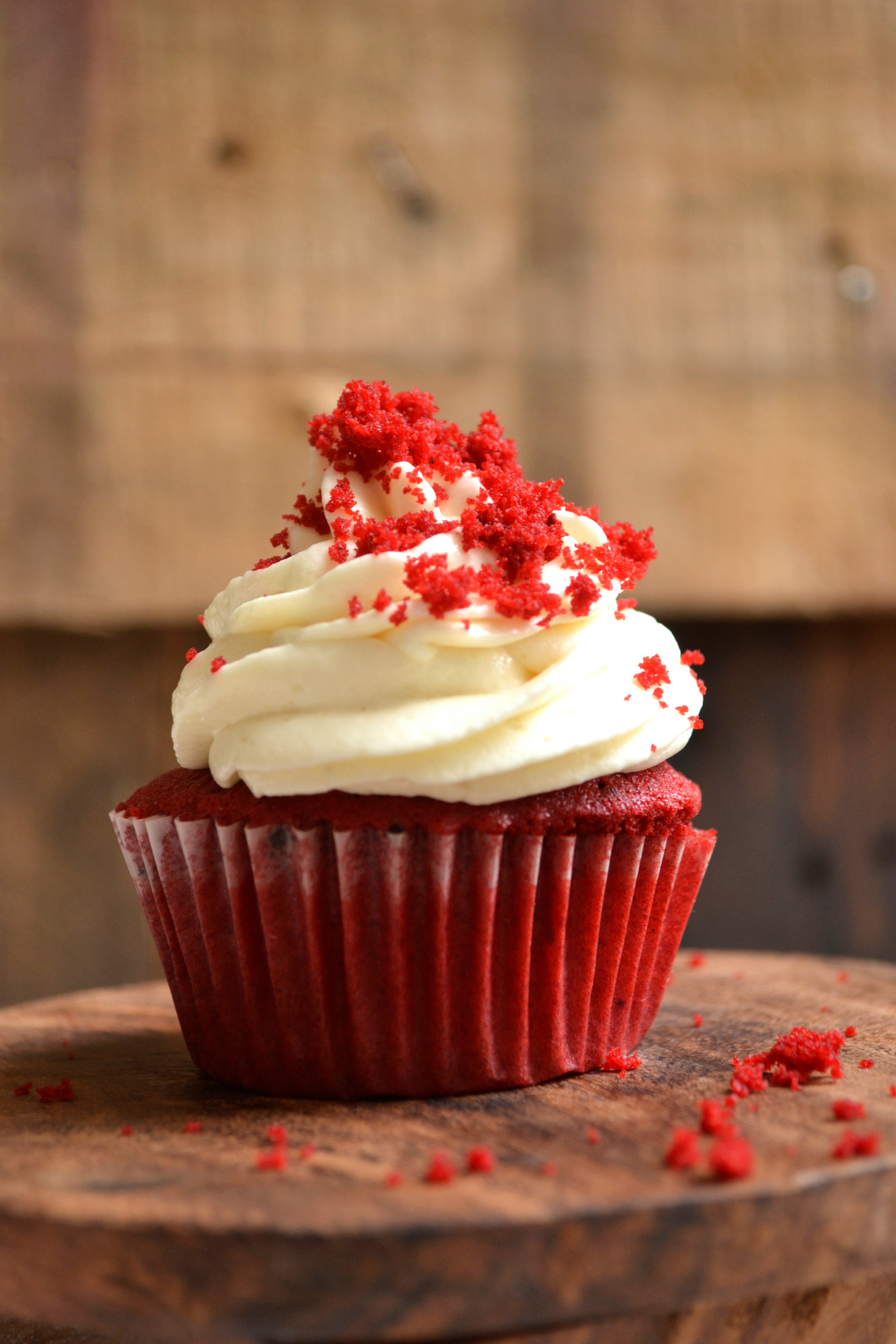 Red velvet cupcake with cream frosting on top.