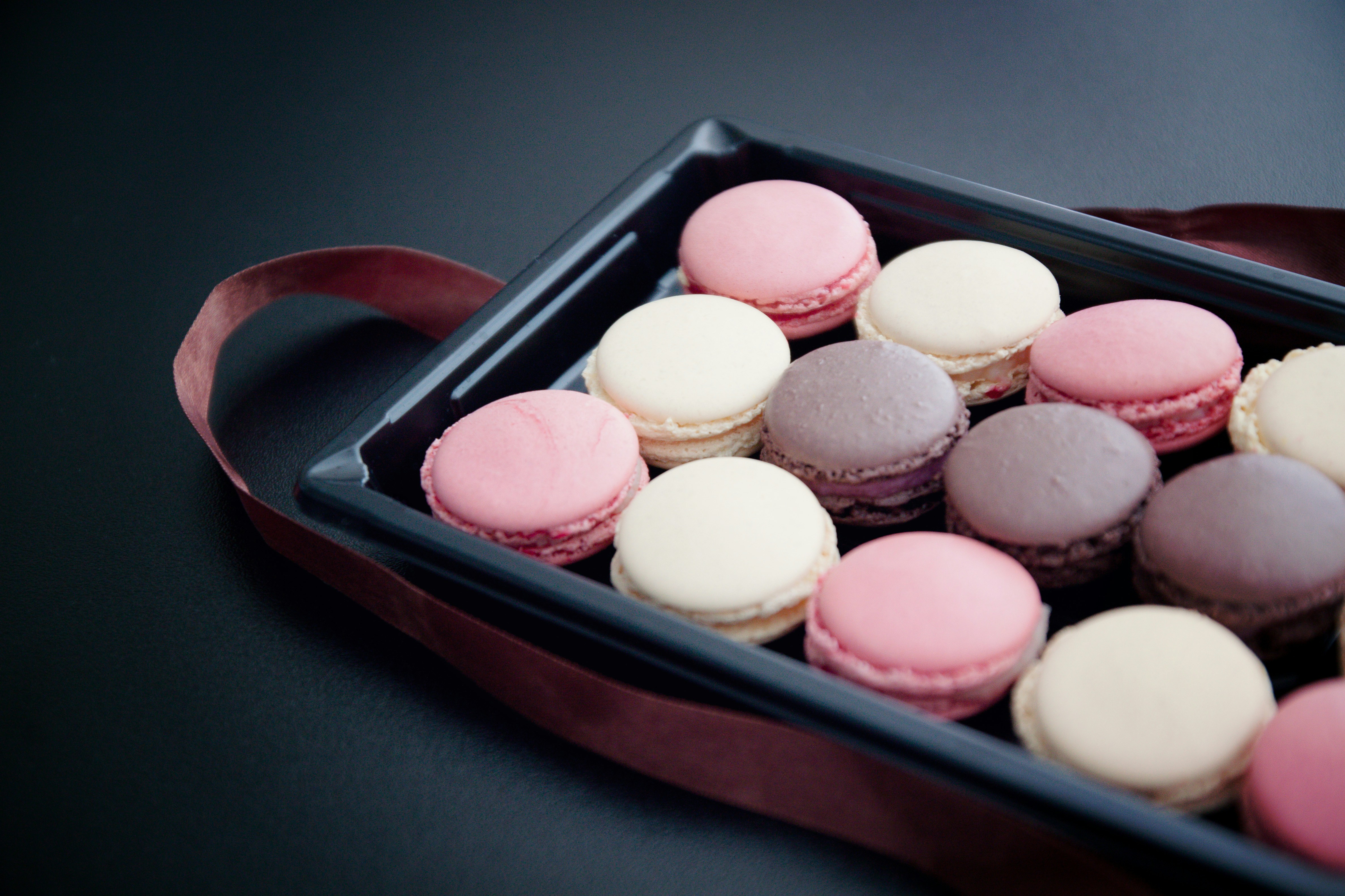 Assorted pink, brown and cream macarons.