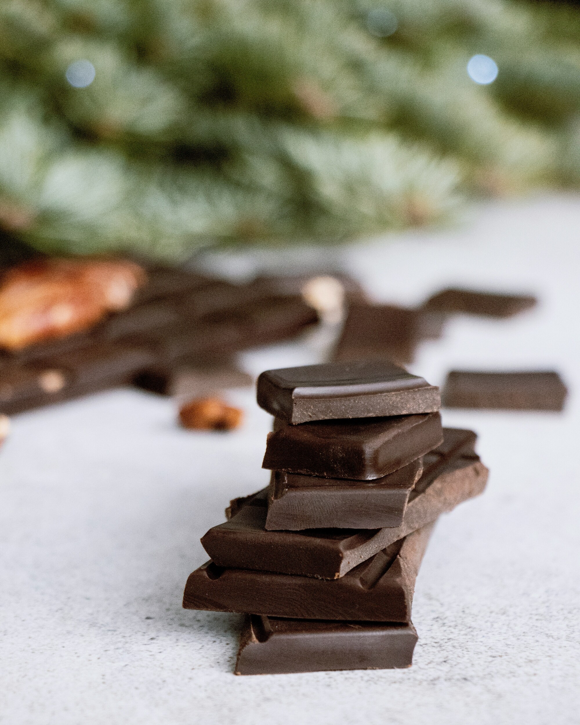Stacked cubes of chocolate against Christmas tree.