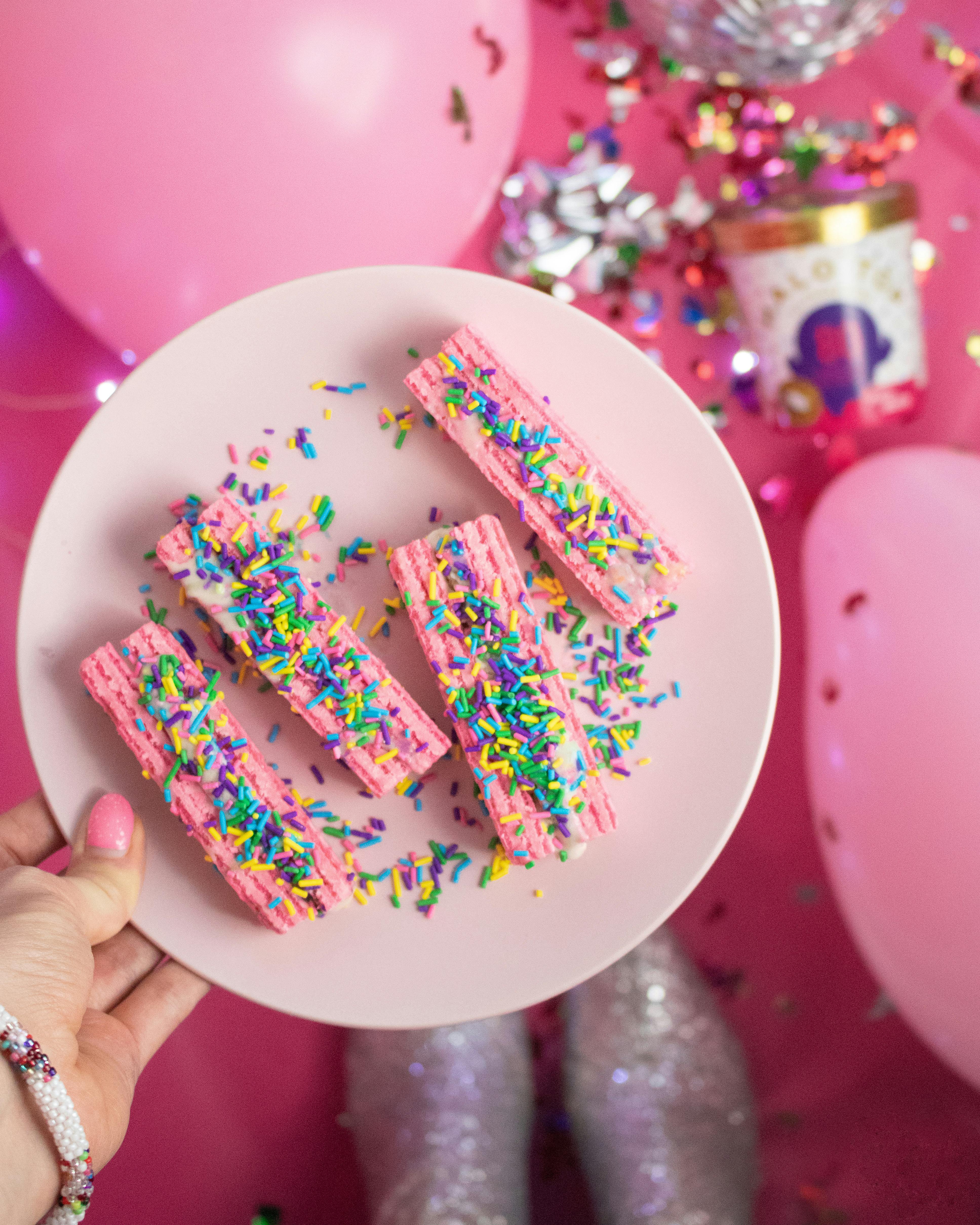 Pink wafers with colourful sprinkles on top.