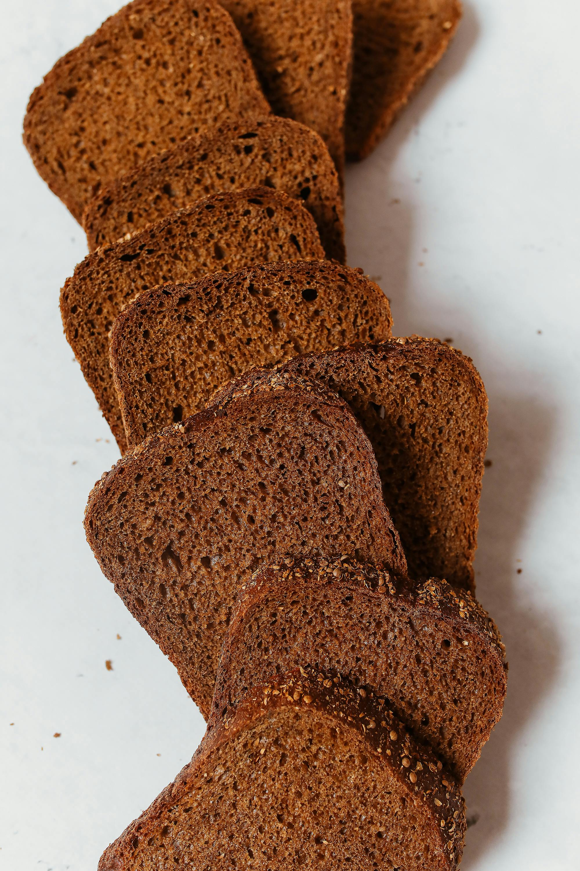 Slices of brown bread against white backdrop.