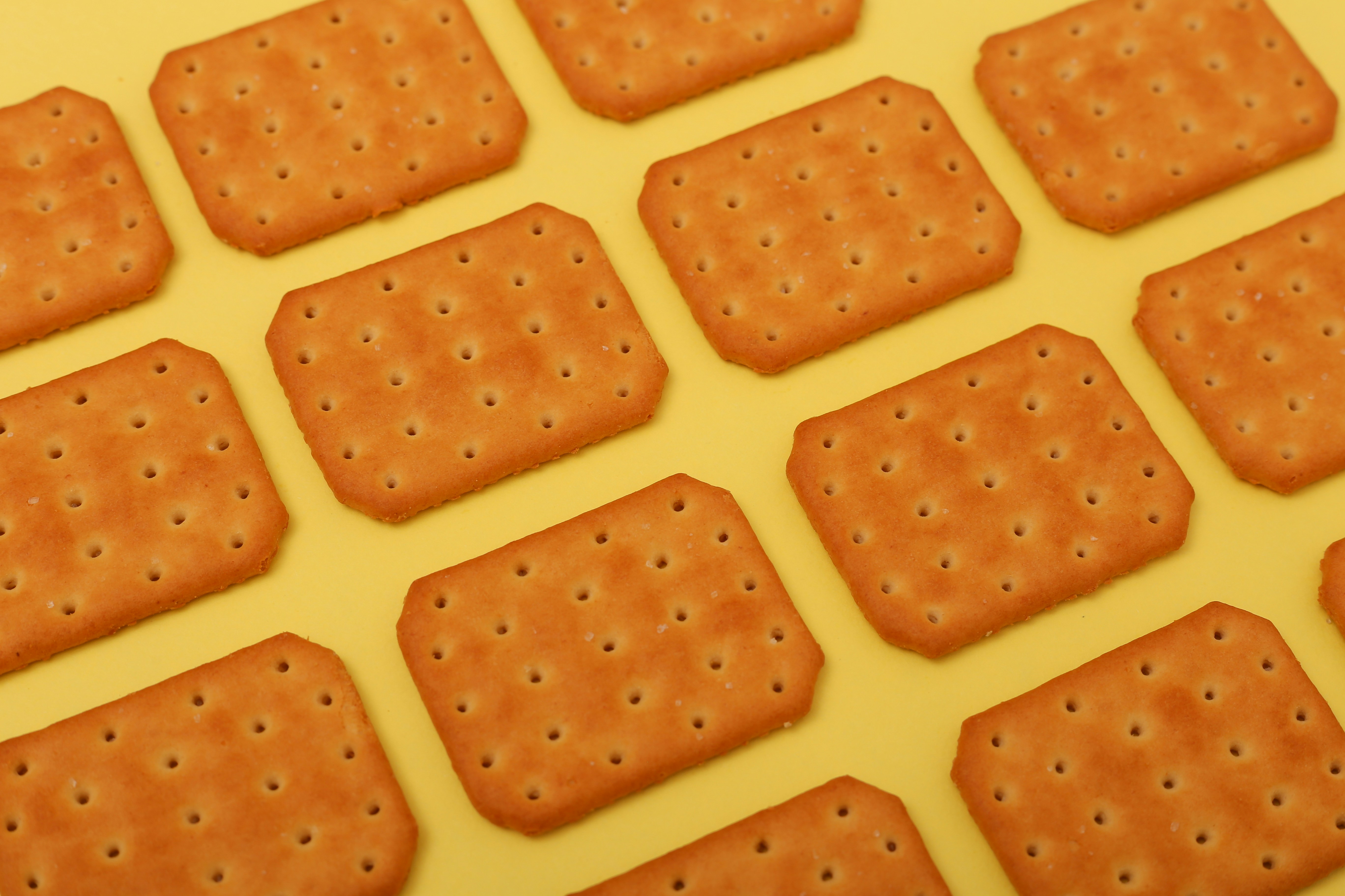 Image of plain crackers against a yellow background.