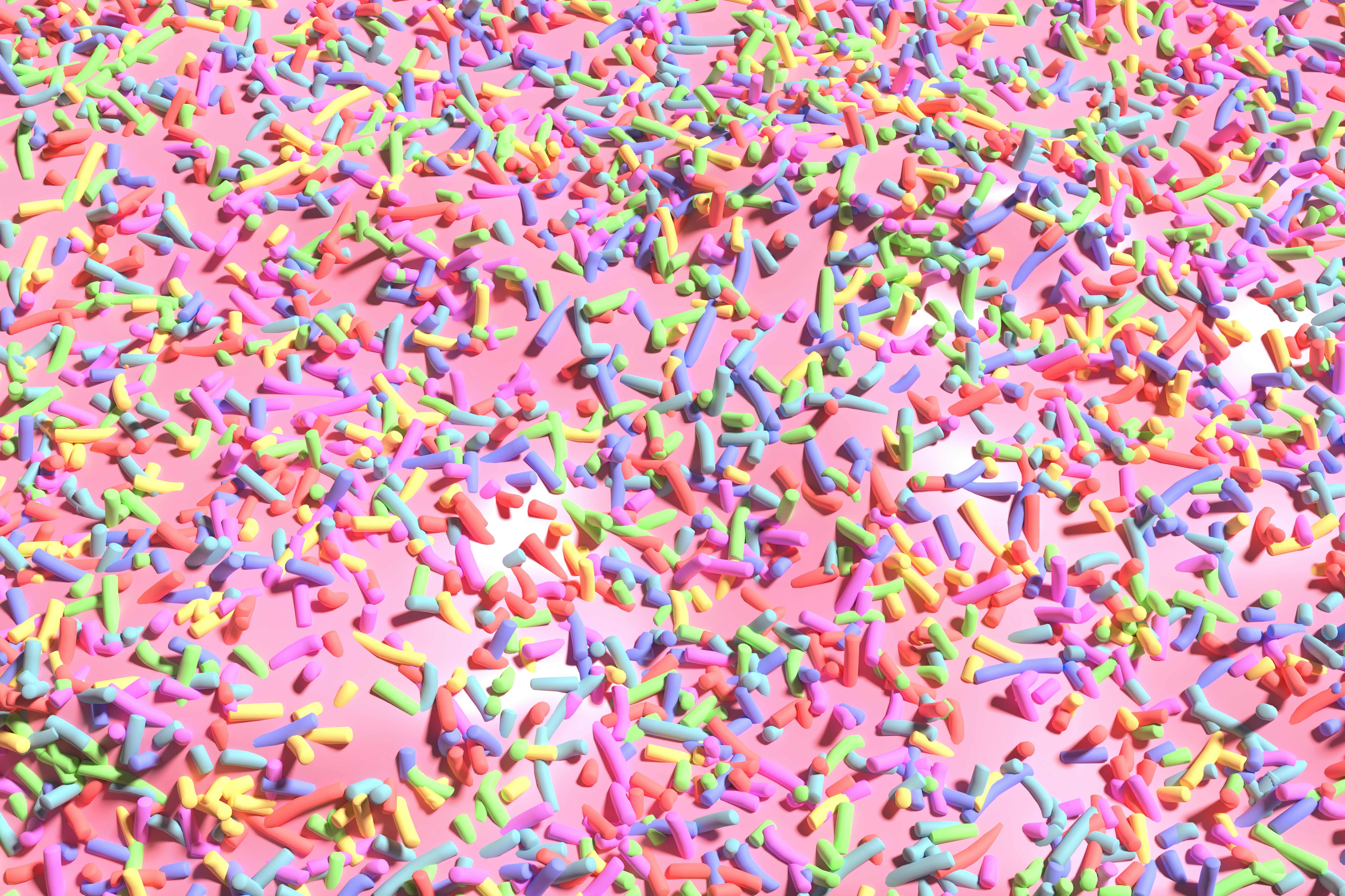Image of pink icing and colourful sprinkles.